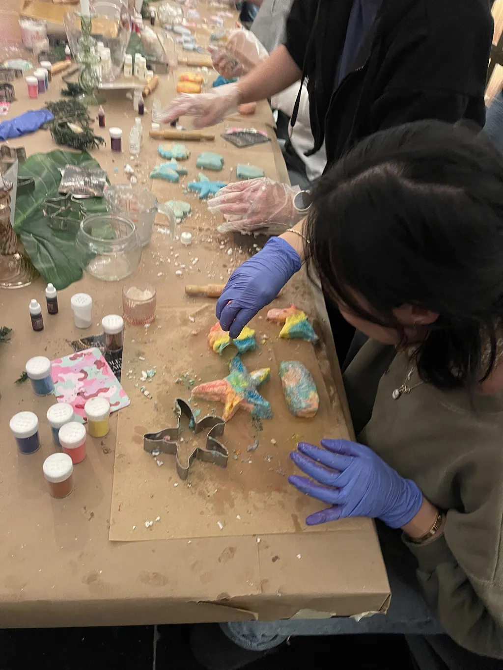 Participant shaping colorful bath bombs using cookie cutters and gloves