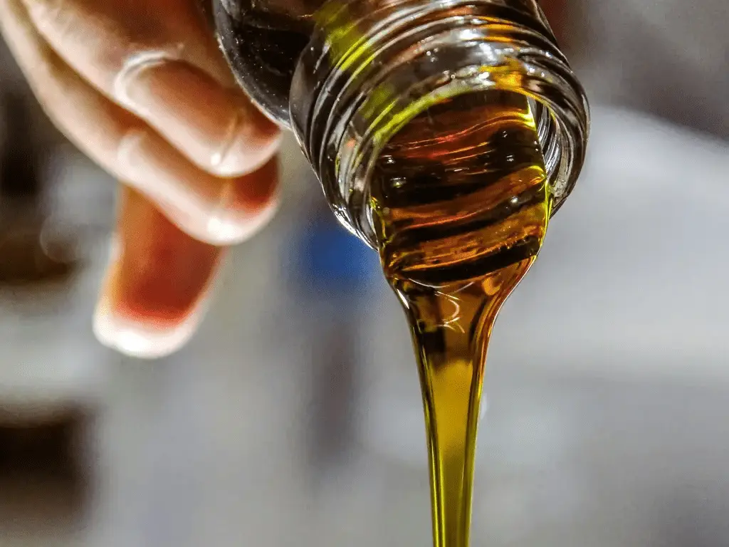 olive oil being poured into a glass
