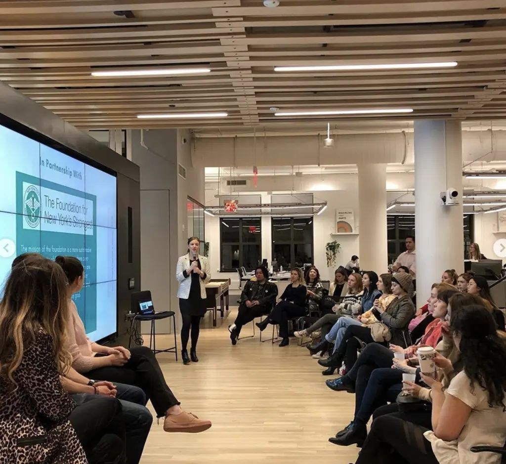 a women standing in front of a crowd of people presenting on sustainability